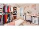 Organized walk-in closet with ample shelving, hanging space, and a vanity area adorned with floral wallpaper at 1144 Simonton Hill Ct, Lawrenceville, GA 30045