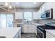 Bright kitchen featuring white cabinets, stainless steel appliances, and sliding glass doors leading to the backyard at 1144 Simonton Hill Ct, Lawrenceville, GA 30045