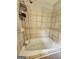 Relax in this bathroom's inviting jetted tub with handheld shower and neutral-toned tile surround and decorative border at 3581 S Hwy 100, Bowdon, GA 30108