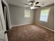 This inviting bedroom features neutral gray walls, plush brown carpet, and a ceiling fan for added comfort at 3581 S Hwy 100, Bowdon, GA 30108