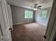 This inviting bedroom features neutral gray walls, plush brown carpet, and a ceiling fan for added comfort at 3581 S Hwy 100, Bowdon, GA 30108