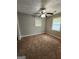 This inviting bedroom features neutral gray walls, plush brown carpet, and a ceiling fan for added comfort at 3581 S Hwy 100, Bowdon, GA 30108