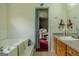 Bright bathroom features a soaking tub, tiled walls, wood cabinets and an open doorway to another room at 1170 Peeksville Rd, Locust Grove, GA 30248