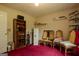 Bedroom with pink carpet, shelves, a wooden bookcase, and four gold wooden chairs at 1170 Peeksville Rd, Locust Grove, GA 30248