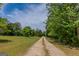 View of a gravel driveway surrounded by trees and greenery leading up to a property at 1170 Peeksville Rd, Locust Grove, GA 30248