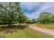 A long driveway leads to a red house with mature trees in the front yard at 1170 Peeksville Rd, Locust Grove, GA 30248