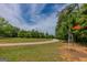 Scenic view of a metal windmill in a yard with trees and a winding gravel driveway under a partly cloudy sky at 1170 Peeksville Rd, Locust Grove, GA 30248