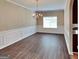 Traditional dining room with elegant chandelier, wainscoting, and wood floors at 4140 Butternut Pl, South Fulton, GA 30349