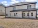 Backyard with white brick, covered patio, and a large lawn area at 209 Langshire Dr, Mcdonough, GA 30253