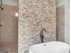 Modern bathroom with soaking tub and shower featuring a stone-style accent wall at 209 Langshire Dr, Mcdonough, GA 30253