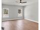 Bright bedroom with hardwood floors, two windows, and a ceiling fan at 209 Langshire Dr, Mcdonough, GA 30253