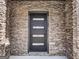 Front door with stone facade, modern design, and sleek hardware at 209 Langshire Dr, Mcdonough, GA 30253