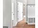 Hallway featuring wood floors, white trim and doorways, with a built-in bench and coat rack at 209 Langshire Dr, Mcdonough, GA 30253