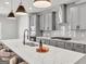 Bright kitchen featuring white marble countertops, gray cabinets, and stainless steel range hood at 209 Langshire Dr, Mcdonough, GA 30253
