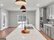 Open-concept kitchen with a large island, white countertops, and views into the living area at 209 Langshire Dr, Mcdonough, GA 30253