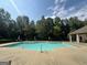 Inviting community pool with lounge chairs, tables, and lush surrounding greenery at 209 Langshire Dr, Mcdonough, GA 30253