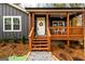 Inviting front porch with wooden stairs, decorative wreath, and manicured landscaping at 79 Turner Dr, Mcdonough, GA 30252