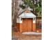 Rustic outbuilding with two-tone finish and double doors, offering stylish storage in wooded backyard at 79 Turner Dr, Mcdonough, GA 30252