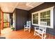 Relaxing outdoor porch featuring rocking chairs, ceiling fan, and stylish paneling details at 79 Turner Dr, Mcdonough, GA 30252