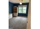 Bedroom with blue walls, carpeted floors, and window with white trim at 171 Galesburg Dr, Lawrenceville, GA 30044