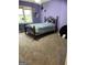 Bedroom with purple walls and carpeted floors features a large window at 171 Galesburg Dr, Lawrenceville, GA 30044