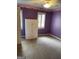 Bedroom with purple walls, white trim, and carpeted floors features natural light at 171 Galesburg Dr, Lawrenceville, GA 30044