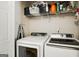 Bright laundry room features modern washer and dryer units, along with overhead storage shelves at 351 Autumn Lake Dr, Mcdonough, GA 30253
