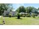 Lovely tree-lined street view of charming single story light blue home with green grass at 1774 Campbellton Rd, Atlanta, GA 30311