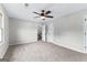 Expansive bedroom with neutral carpet, ceiling fan, white trim, and two doors at 550 Davis Rd, Fayetteville, GA 30215