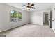 Light-filled bedroom with neutral carpet, ceiling fan, and a window offering scenic views at 550 Davis Rd, Fayetteville, GA 30215