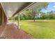 Long covered front porch showing brick mosaic tile, white pillars and expansive lawn with beautiful trees at 550 Davis Rd, Fayetteville, GA 30215