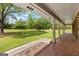 Inviting covered porch with brick flooring, flower beds, and beautiful view of the expansive, green front lawn at 550 Davis Rd, Fayetteville, GA 30215