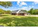 Spacious yard with a well-maintained lawn, a brick home with a covered porch, and a detached garage at 550 Davis Rd, Fayetteville, GA 30215