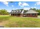 Brick home featuring black shutters, dormer windows and a well-manicured lawn, offering classic curb appeal at 550 Davis Rd, Fayetteville, GA 30215