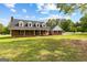 Charming brick home featuring black shutters, dormer windows and a spacious front yard with mature trees at 550 Davis Rd, Fayetteville, GA 30215
