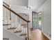 Bright foyer featuring wood flooring, a staircase with white spindles, and view of the front yard through glass door at 550 Davis Rd, Fayetteville, GA 30215