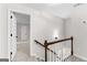 Bright hallway features wood railing, white walls, and neutral carpet leading to an open doorway at 550 Davis Rd, Fayetteville, GA 30215
