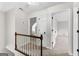 Hallway features white doors, wood railing, neutral carpet, and an open doorway at 550 Davis Rd, Fayetteville, GA 30215