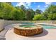 Resort-style pool area featuring a stone hot tub and fenced yard at 550 Davis Rd, Fayetteville, GA 30215