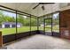 Inviting screened porch offering ample seating area with brick accent wall and view of backyard at 550 Davis Rd, Fayetteville, GA 30215