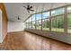 Bright sunroom with hardwood floors, ceiling fans, and large windows showcasing the lush outdoor view at 550 Davis Rd, Fayetteville, GA 30215
