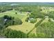 Aerial view of a home surrounded by lush landscape, greenery and a lake in the distance at 1040 Rock Creek Rd, Social Circle, GA 30025
