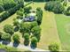 Aerial view of home with in-ground pool nestled among mature trees on expansive green property at 1040 Rock Creek Rd, Social Circle, GA 30025