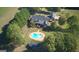 Aerial view of a property featuring a backyard pool, lush landscaping, and a well-maintained lawn at 1040 Rock Creek Rd, Social Circle, GA 30025