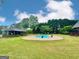 A large backyard features an in-ground pool, an outbuilding and lush landscaping at 1040 Rock Creek Rd, Social Circle, GA 30025