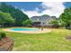 A spacious backyard featuring an in-ground pool, lush green lawn, and an inviting home exterior at 1040 Rock Creek Rd, Social Circle, GA 30025