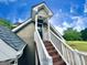 Exterior staircase with white railings leading to a doorway, with blue skies overhead at 1040 Rock Creek Rd, Social Circle, GA 30025