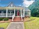 Charming home with brick stairs, a white porch and a vibrant red front door at 1040 Rock Creek Rd, Social Circle, GA 30025