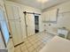 Bright laundry room features tile floors, utility sink, cabinets, and barn door to pantry at 1040 Rock Creek Rd, Social Circle, GA 30025