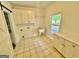 Bright laundry room features tile floors, utility sink, cabinets, and a window at 1040 Rock Creek Rd, Social Circle, GA 30025